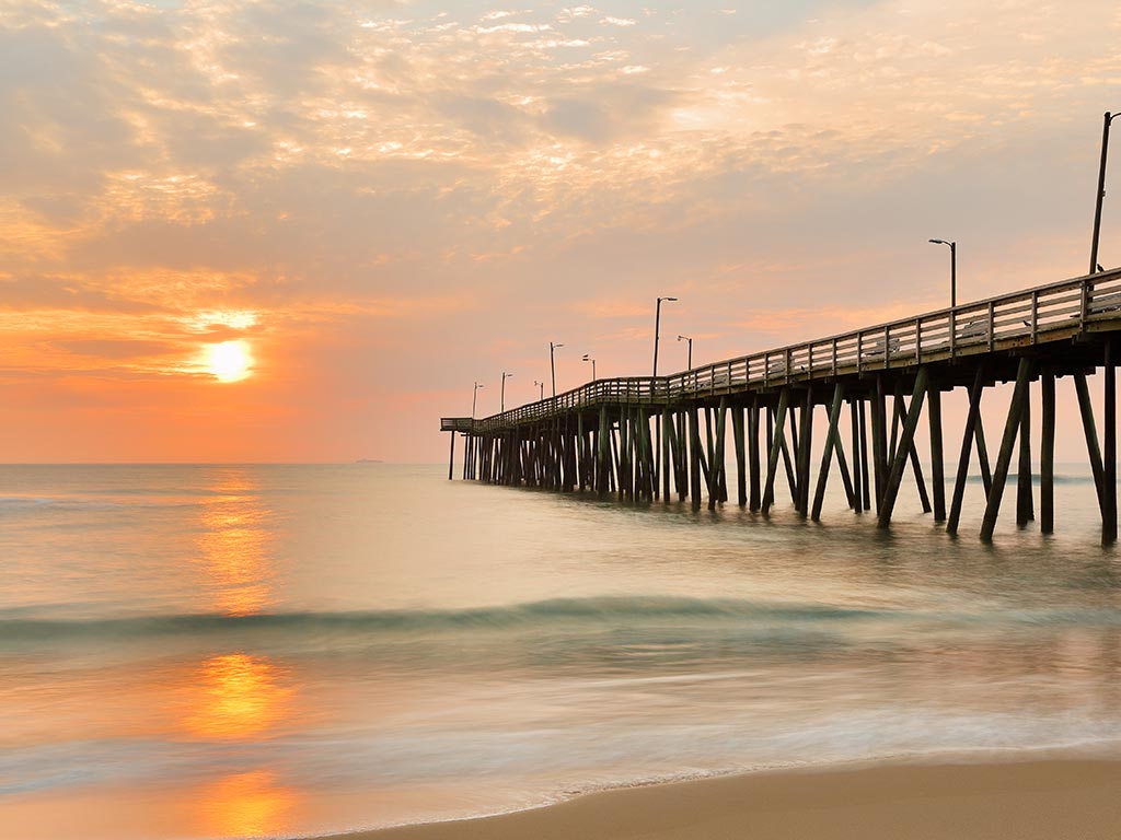 A fishing pier in Virginia Beach with the sunrise in the background.