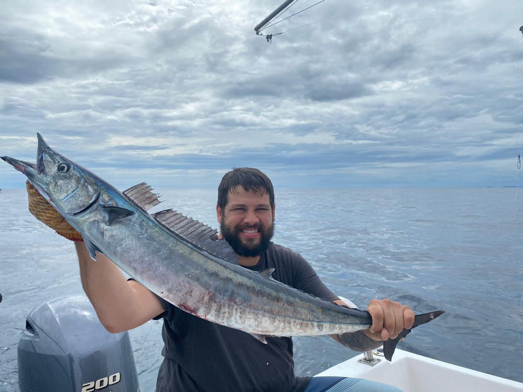 An angler on a charter boat, holding a Wahoo he reeled in at the start of the wet season in Costa Rica.