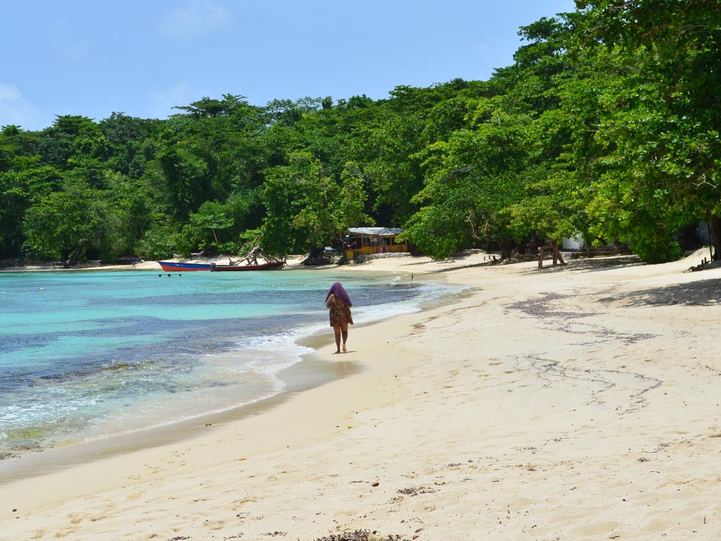 Winnifred Beach on a sunny day with a woman walking across the beach.