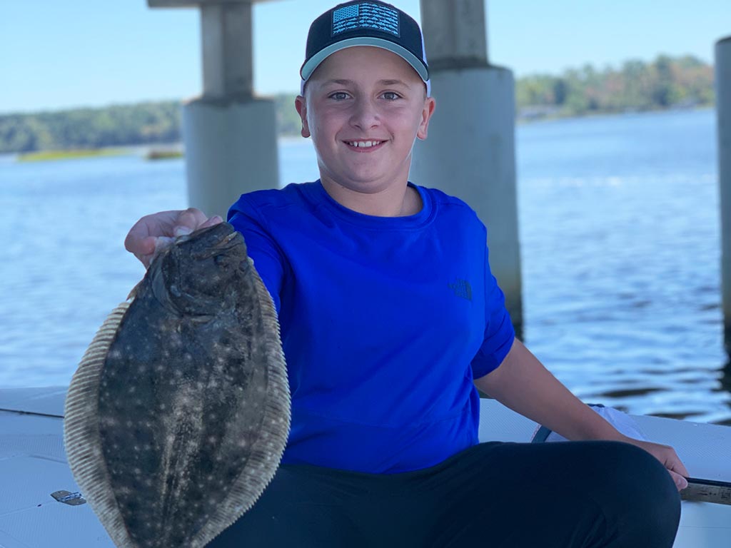 A young angler holds up a Flounder caught in the Bogue Sound, near Emerald Isle.