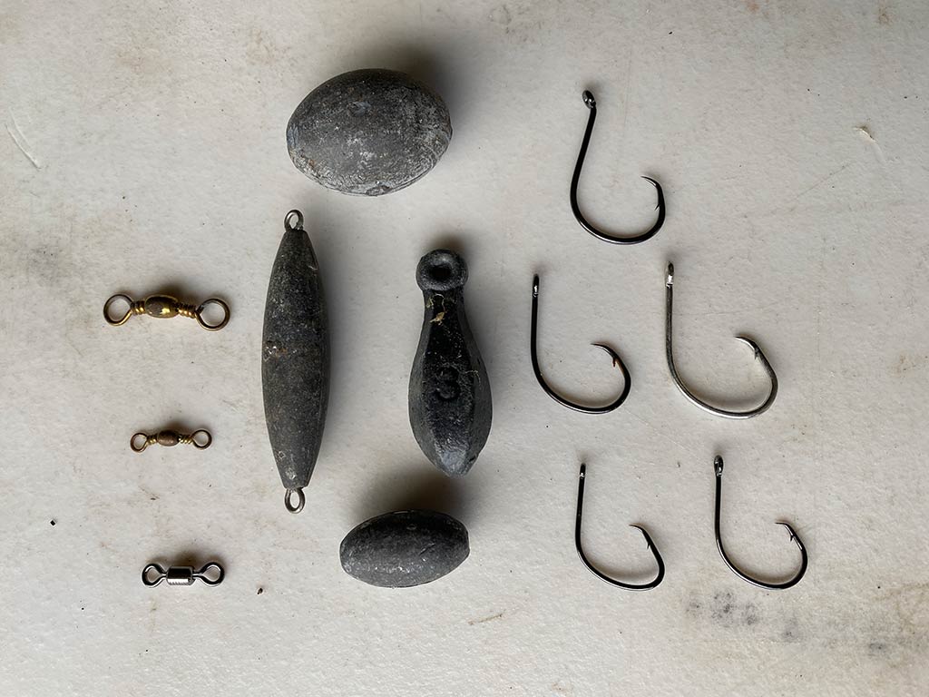 A bird's eye view of hooks and tackle on a table, suitable for fishing for Catfish in Louisiana