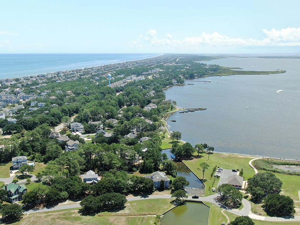 An aerial view of Corolla, NC, with the sound on the right-hand side of the image, and the Atlantic Ocean on the left. 