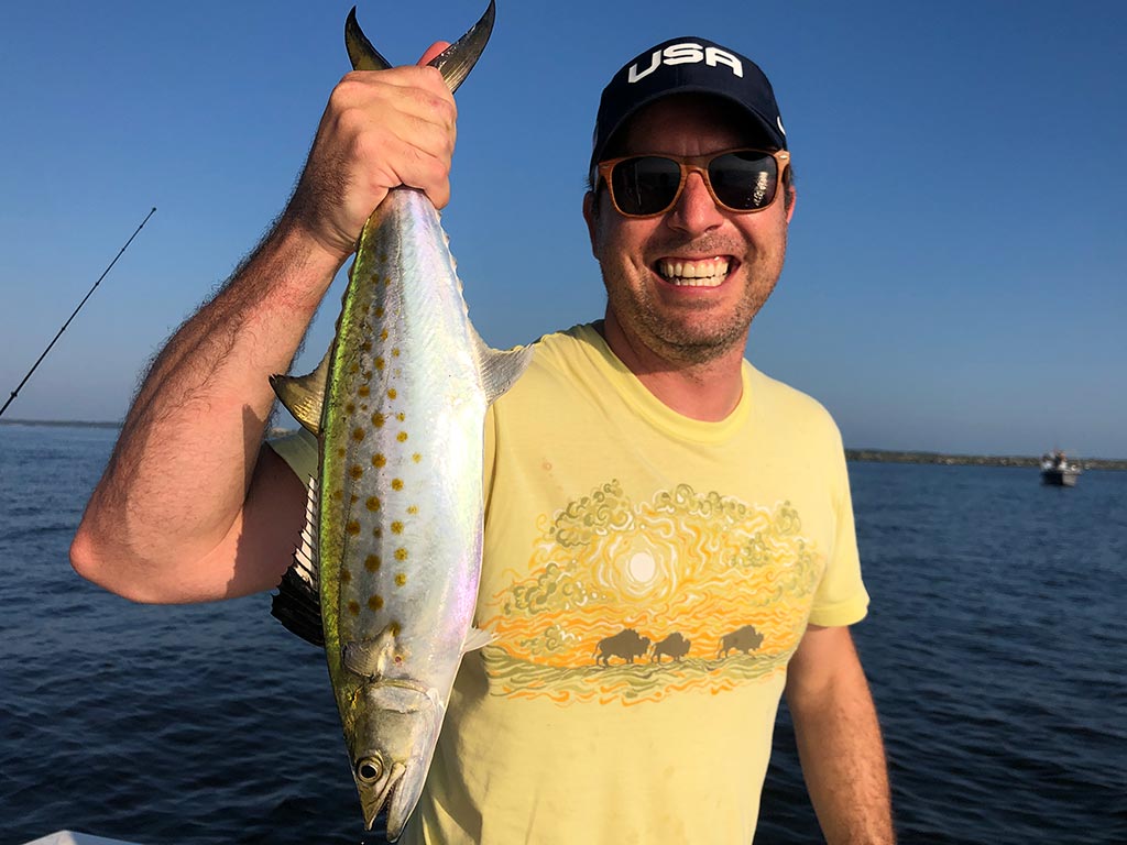 A smiling angler holds a Spanish Mackerel just caught somewhere near Annapolis