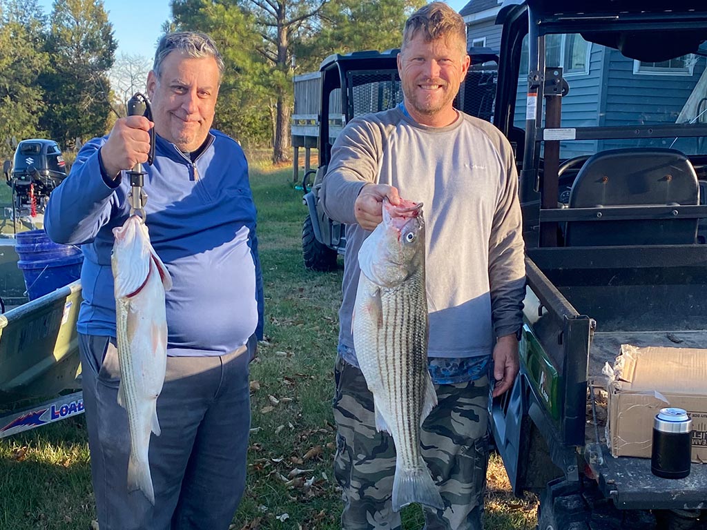 A pair of anglers holding a pair of Rockfish they caught near Annapolis while back on dry land