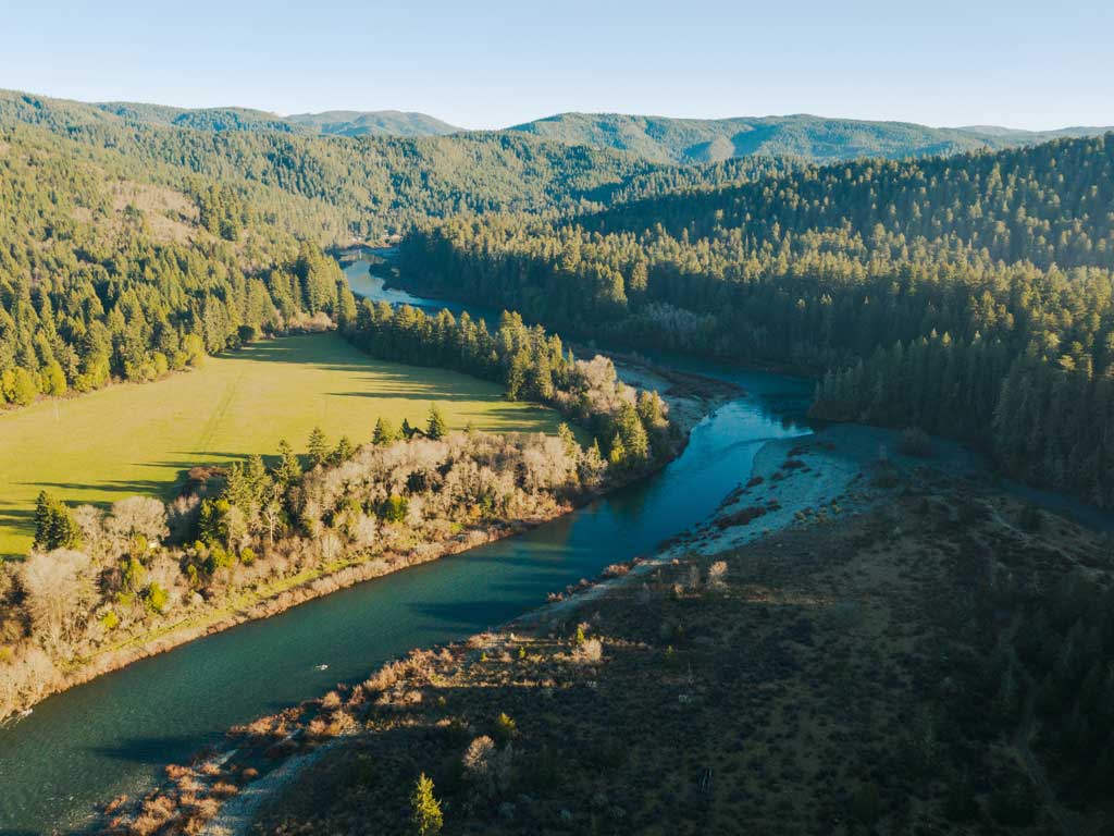 An aerial photo of the Smith River and the forest surrounding it in Del Norte County, one of the best fishing destination you can travel to on Presidents' Day.