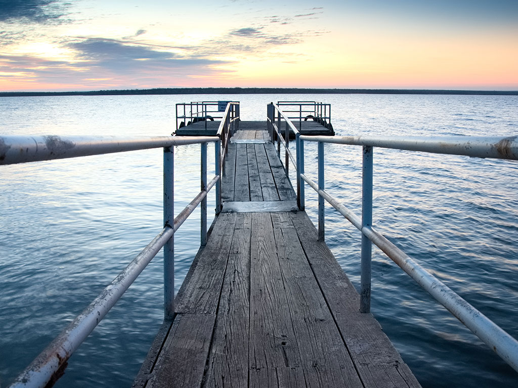 A view along a pier that also acts as a dock for fishing boats on Millers Creek Reservoir, one of West Texas's prime Catfish destinations