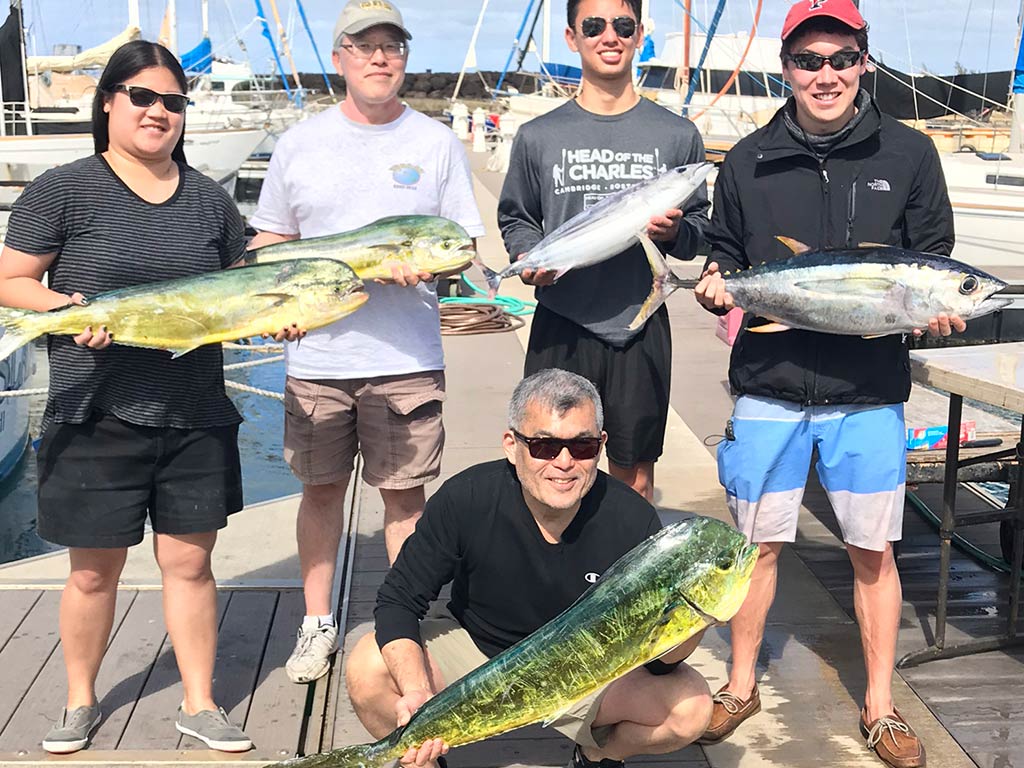 A group of anglers back on the dock after a successful fishing trip, holding their catch of Mahi Mahi and Tuna on a sunny day