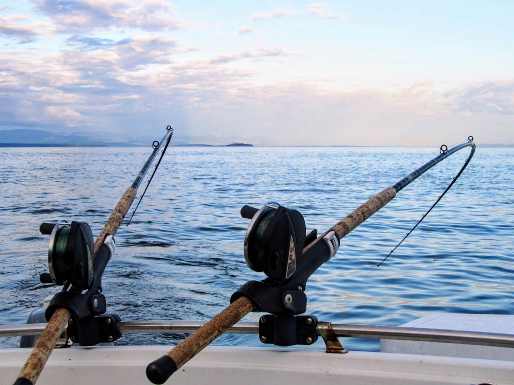 A photo of the nearshore waters and two fishing rods attached to a charter boat while drift fishing slowly and moving the lines in the current’s direction