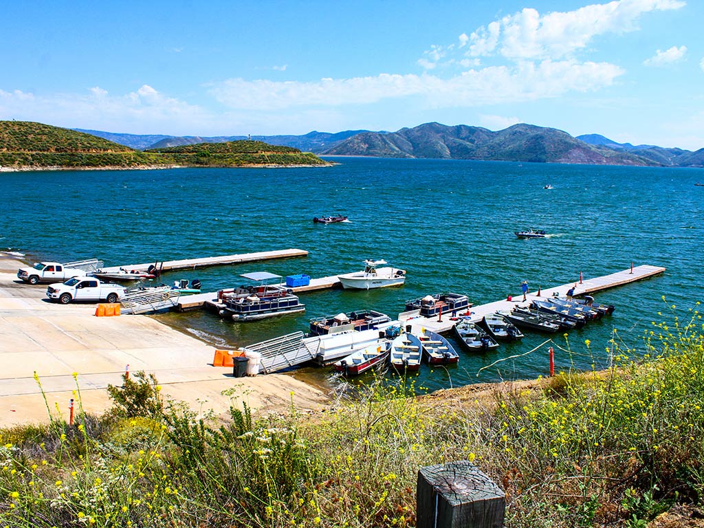 A view from a hill down towards the shoreline and a dock on Diamond Valley Lake, California, on a sunny day