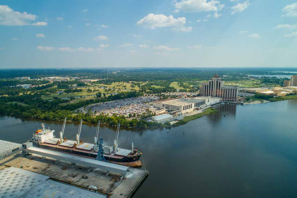 An aerial view of Lake Charles, Louisiana – both the town and watershed – with a big cargo ship on the water on a clear day