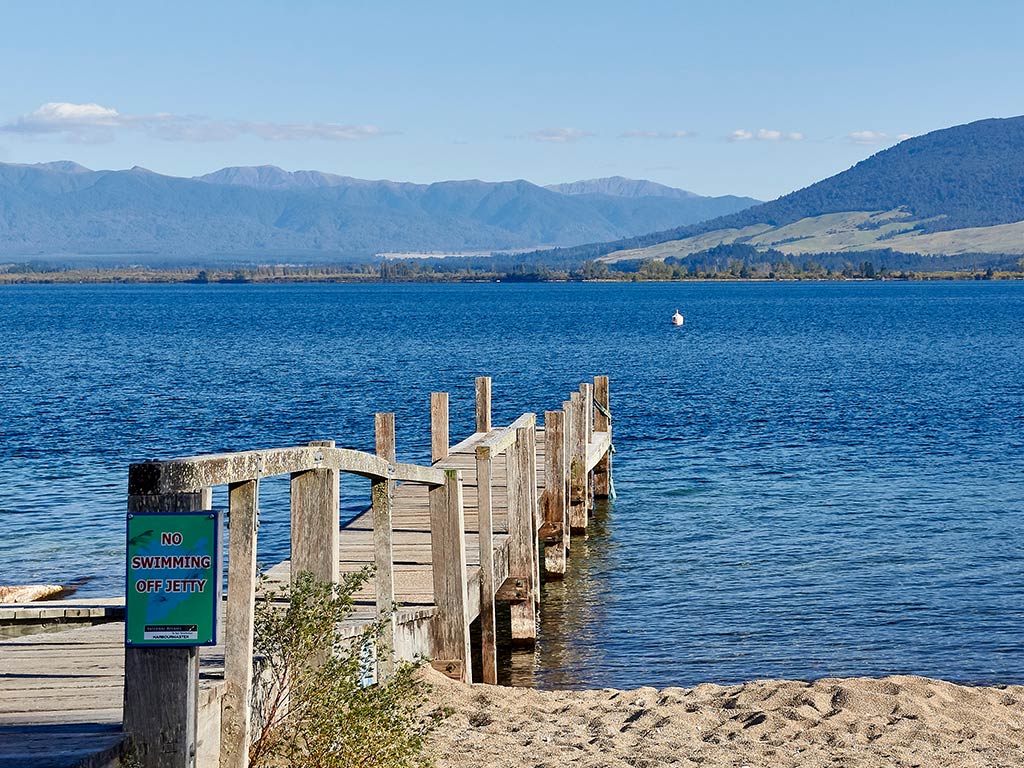 A view out across a small, wooden fishing jetty on Lake Taup