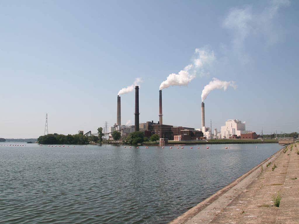 A view across Lake Springfield towards the power plant on a sunny day, with smoke coming out of the chimneys on a clear day