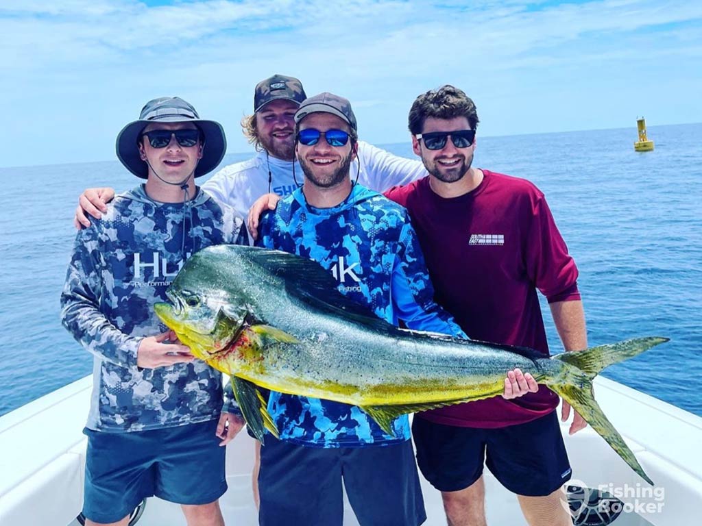 A group of male anglers of different ages pose aboard a fishing charter near Santa Rosa Beach, FL, with a colorful Mahi Mahi they landed on a sunny day