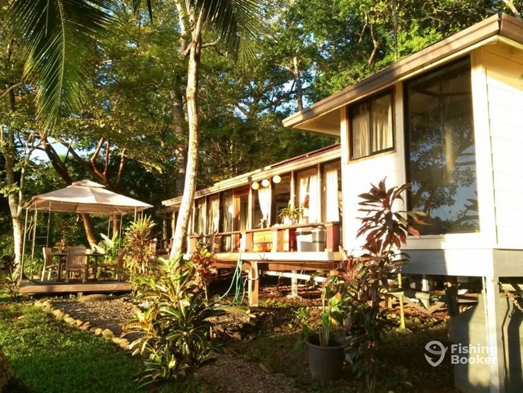 A view towards a pristine wooden lodge in Panama, surrounded by trees on a sunny day