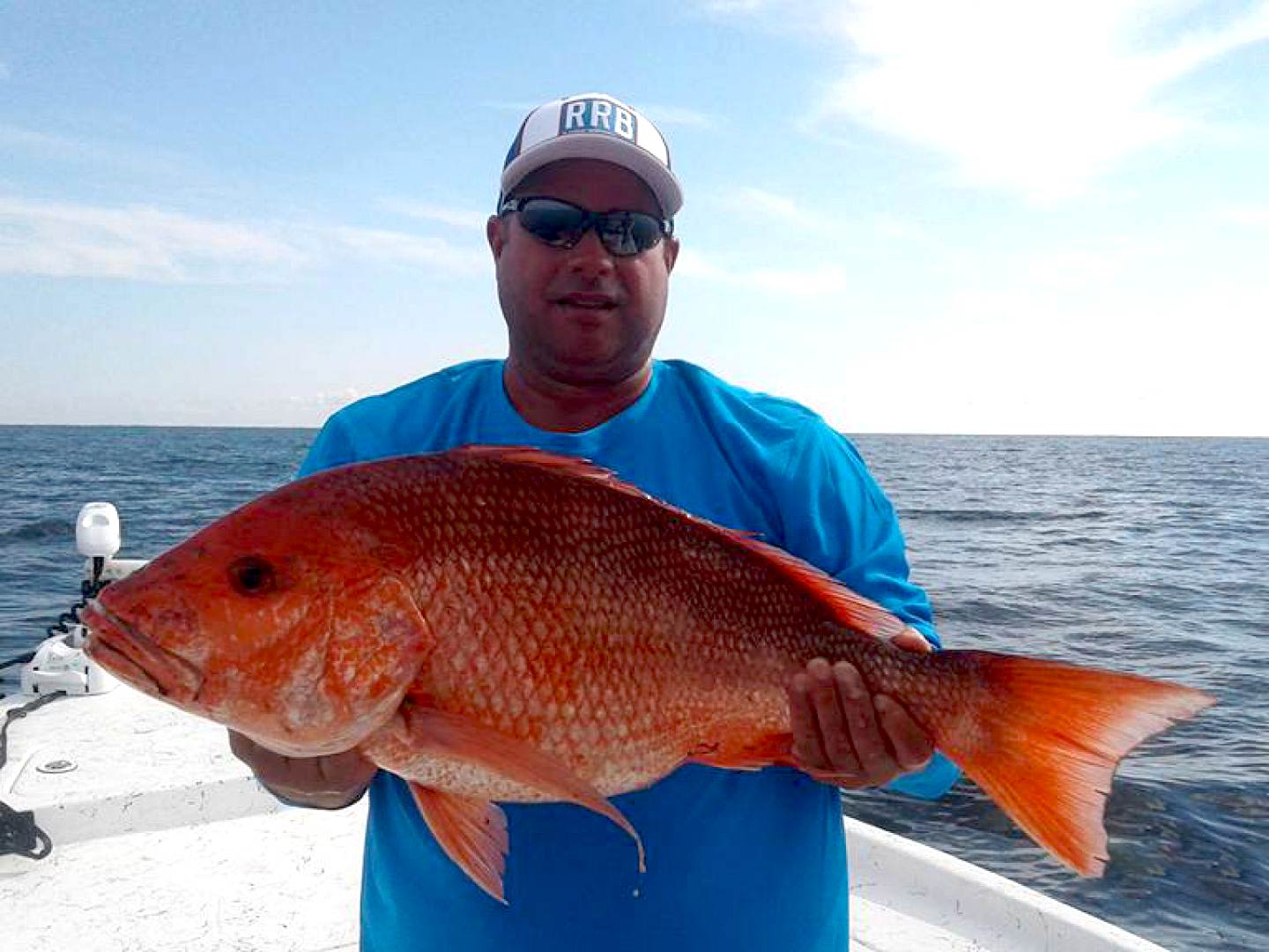 A man holding a Snapper on a boat in Florida