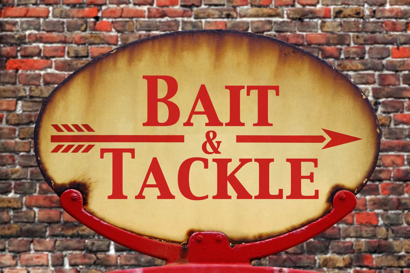 A vintage red and yellow bait and tackle sign against a brick wall