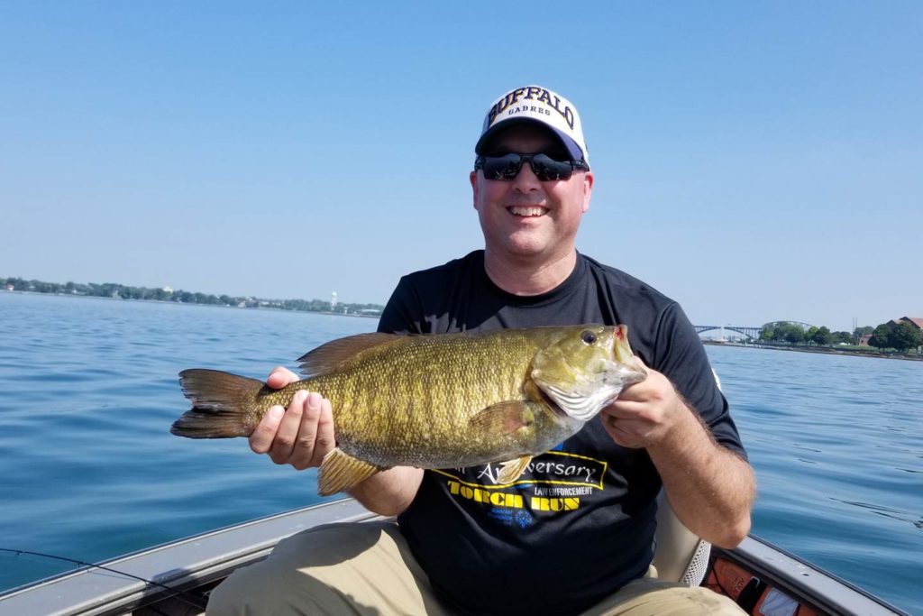 A male angler partaking in some summer Bass fishing on Lake Ontario.