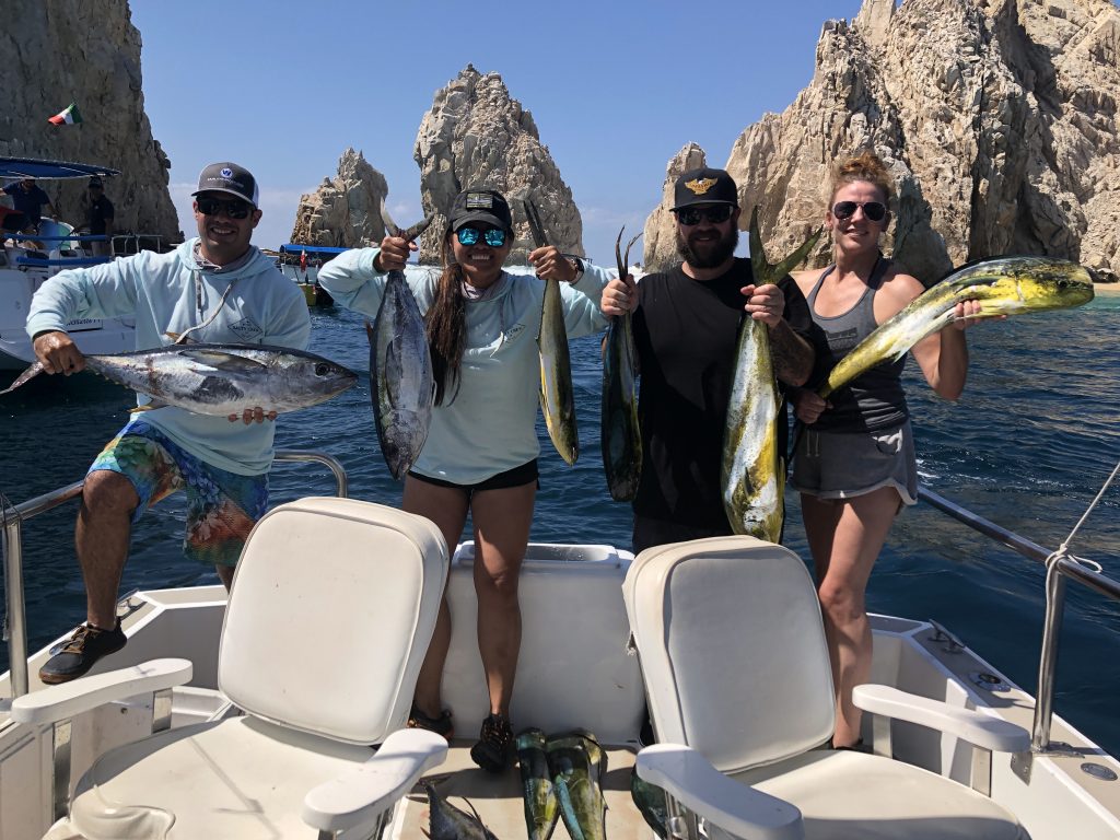 pescadores sonrientes con su captura en un barco de pesca cerca de Cabo San Lucas