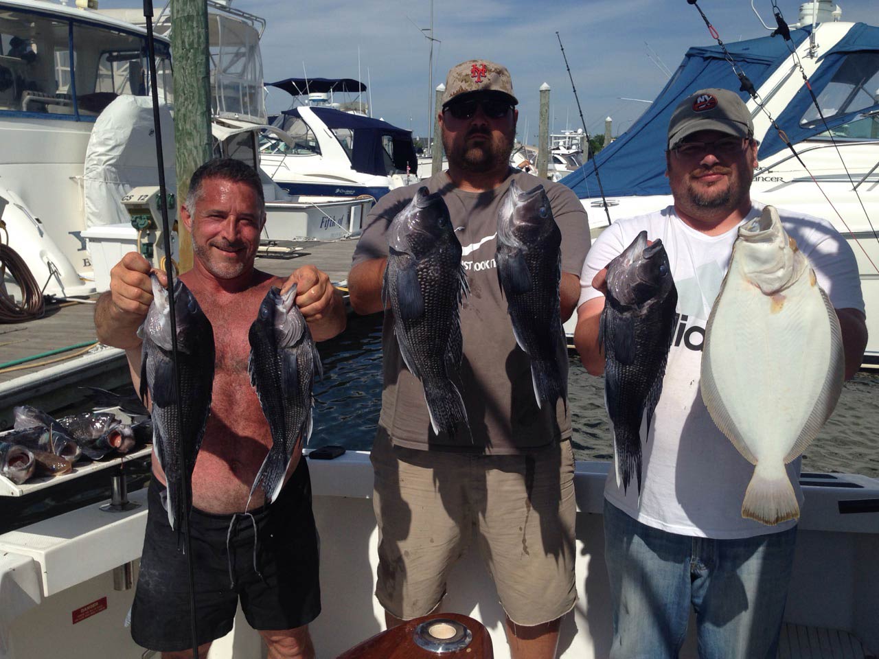 A group of anglers hold Black Seabass caught on a successful fishing trip from Captree
