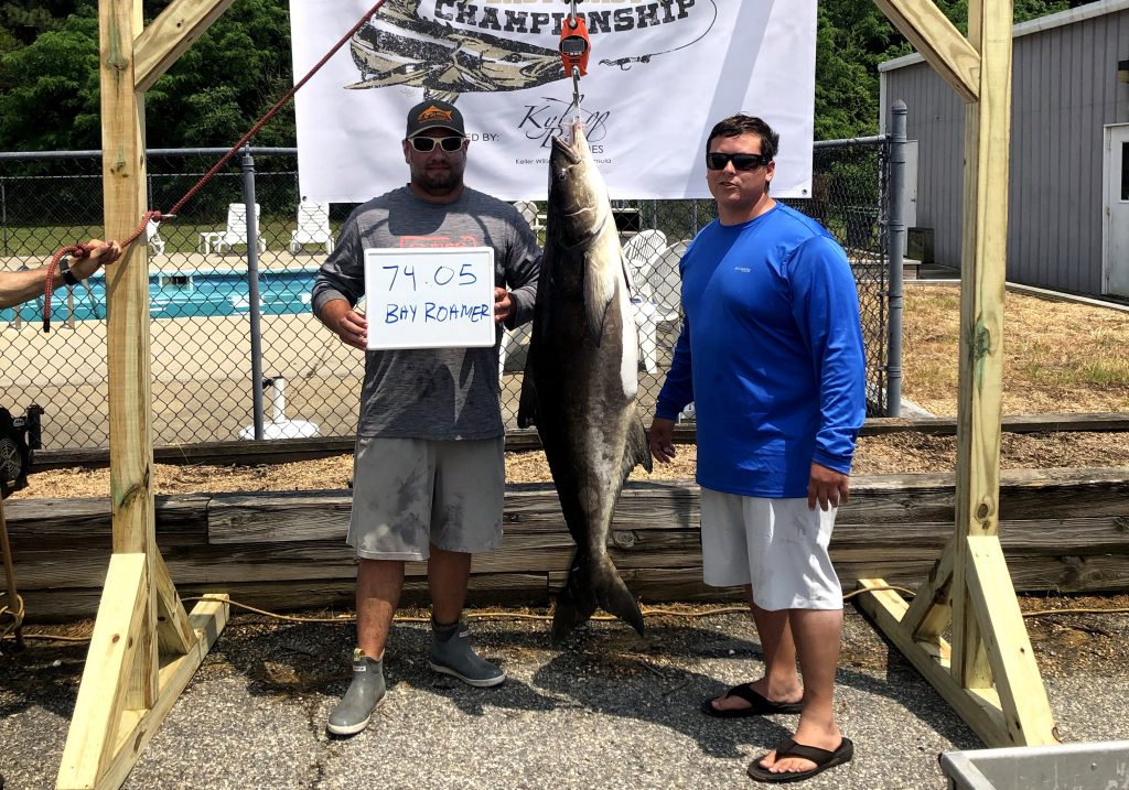 Two anglers posing with their tournament-winning cobia hanging between them