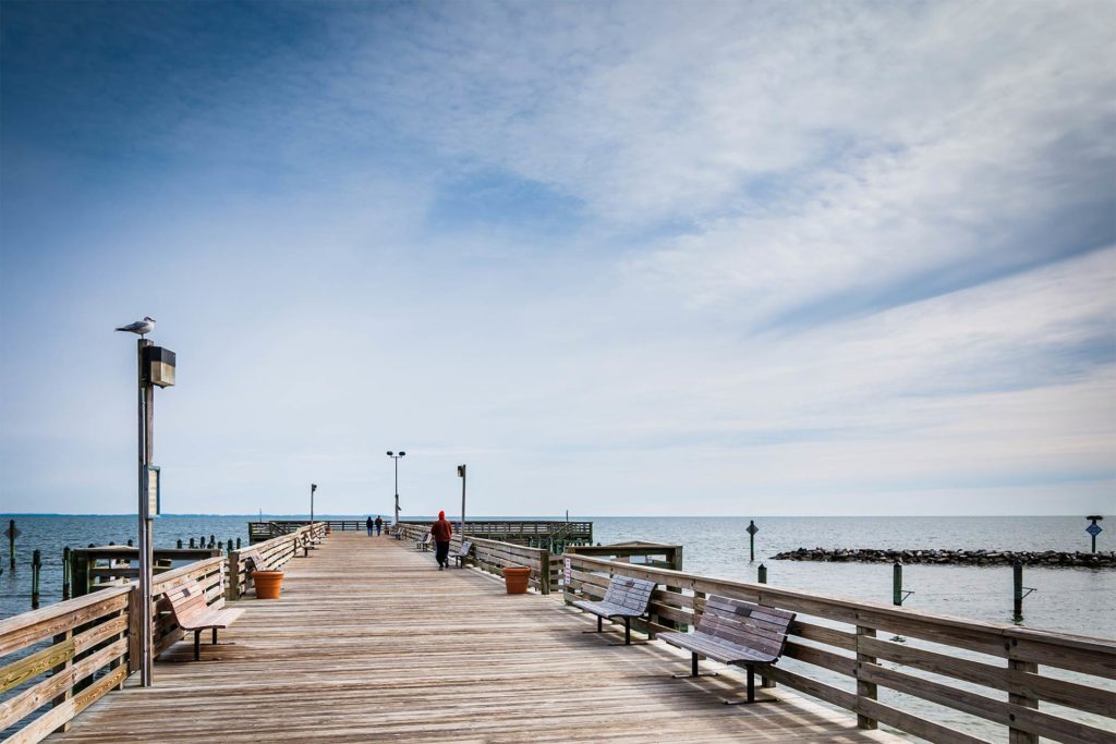 A fishing pier leads out next to a small jetty in the Chesapeake Bay