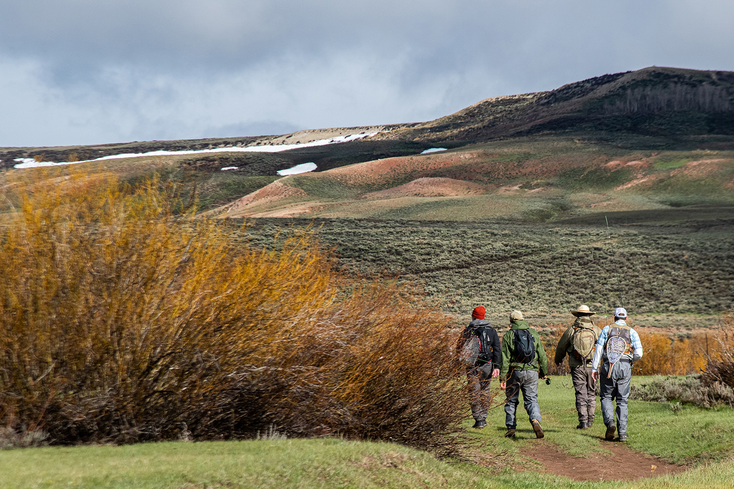 A group of fly fishers hiking out in remote countryside