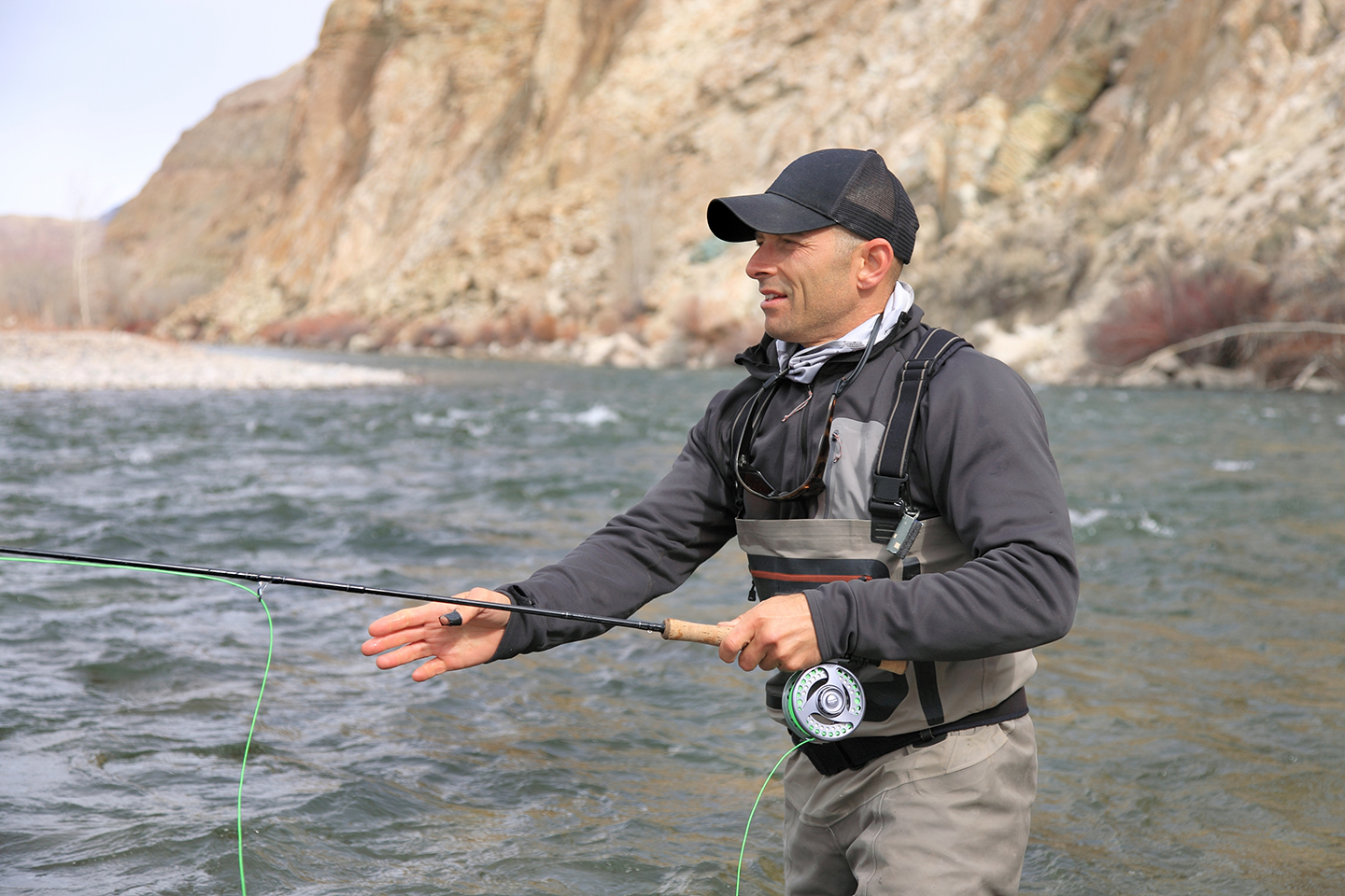 A fly fisherman focusing on his line while he tries to catch a fish