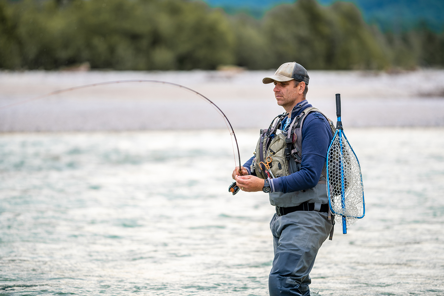 A veteran fly fishing in a river as part of a fishing therapy retreat
