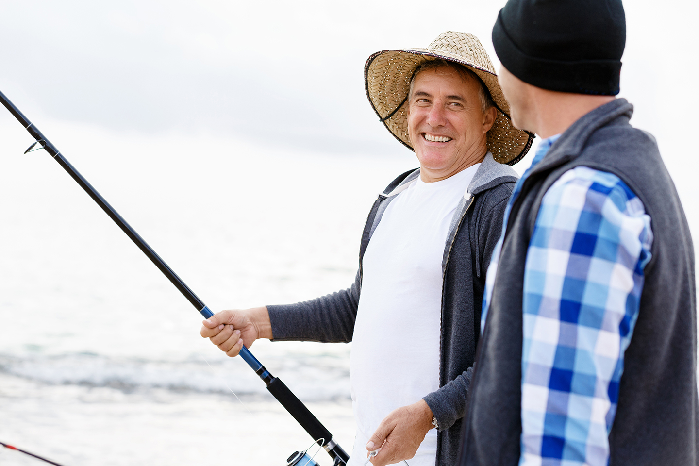 Two happy fishermen, one with a rod in his hand