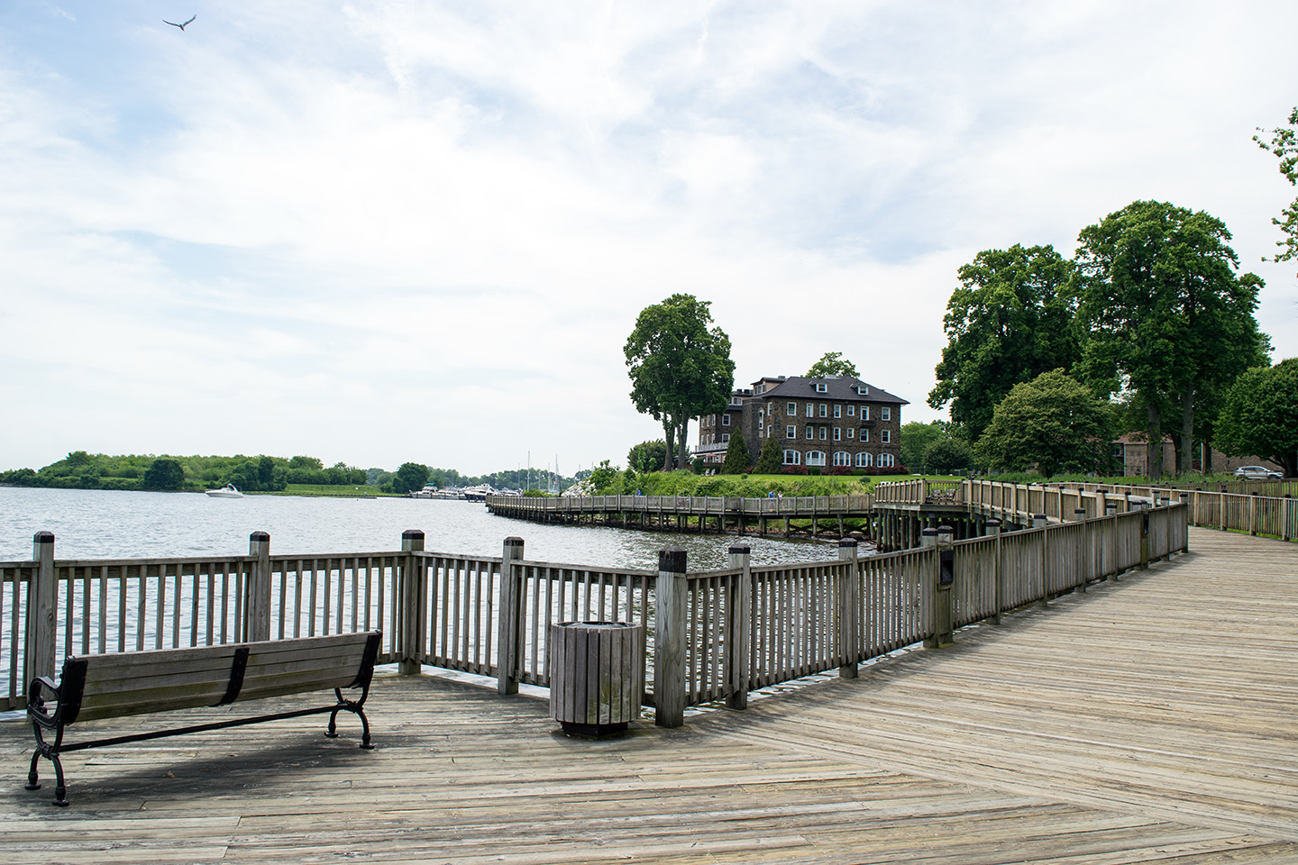 A wooden waterfront walkway in Havre de Grace, MD, with an old brick building in the distance