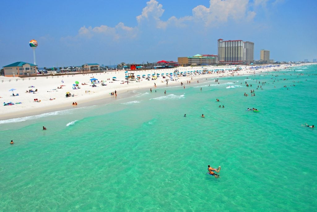 A busy summer's day on Pensacola Beach, with lots of people in the sea and on the beach