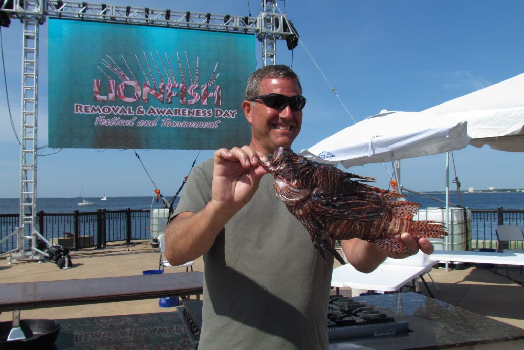 A man holding a large Lionfish caught at the Pensacola Lionfish Classic