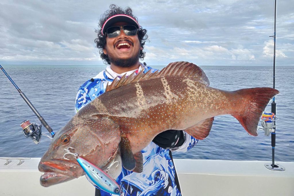 A happy angler showing off a fish caught over the reefs