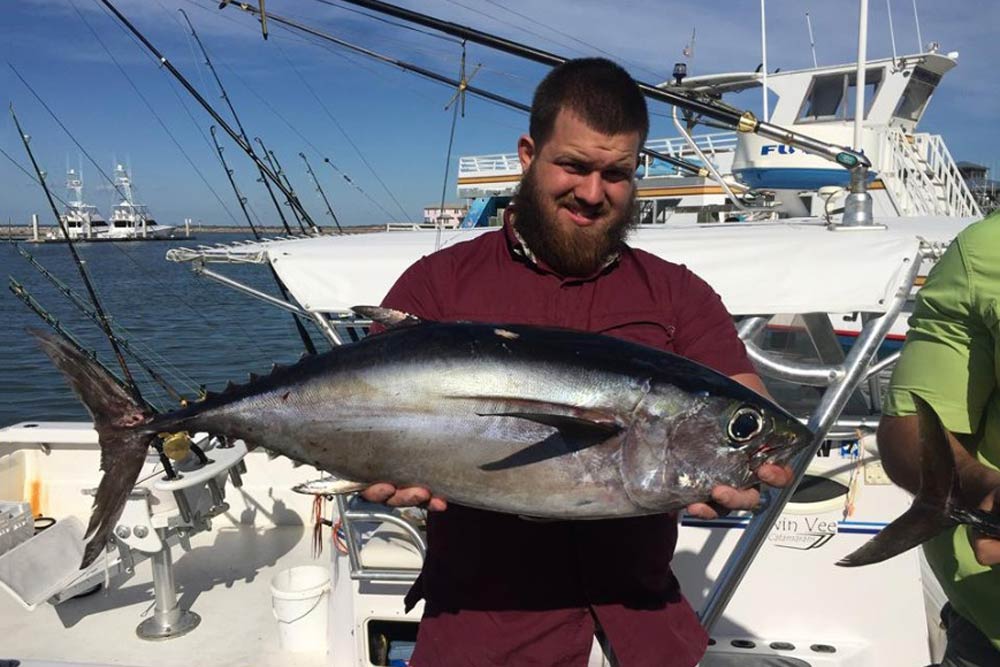A man holding a Blackfin Tuna after getting back to the marina