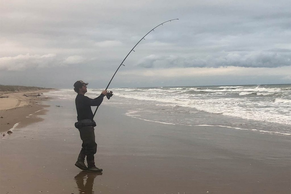 A man casting from the beach