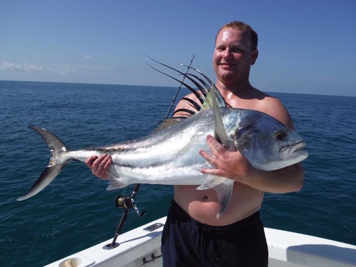 un pêcheur tenant un poisson-coq qu'il a pêché près de Cabo San Lucas