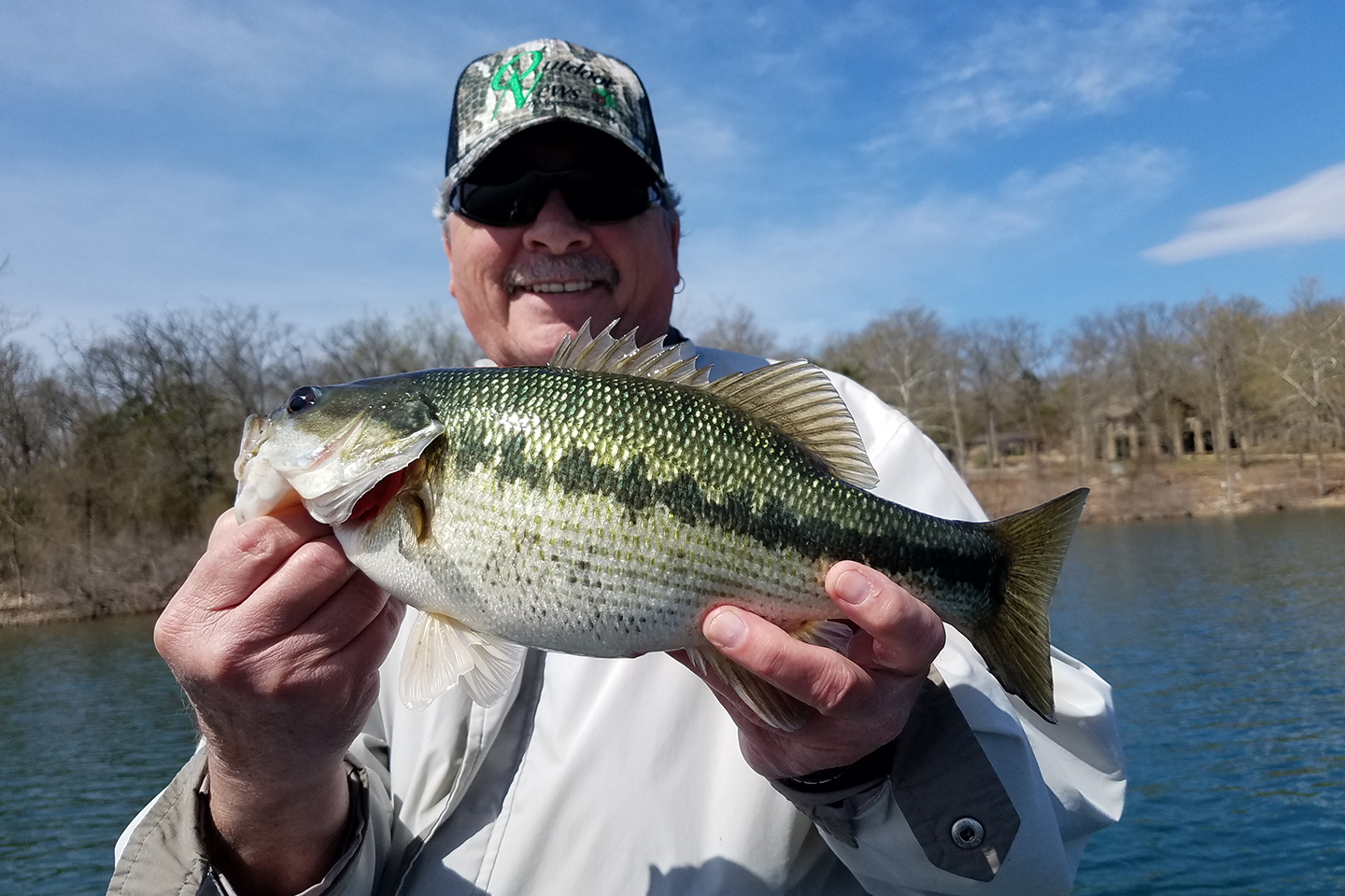 An angler holding up a large Spotted Bass