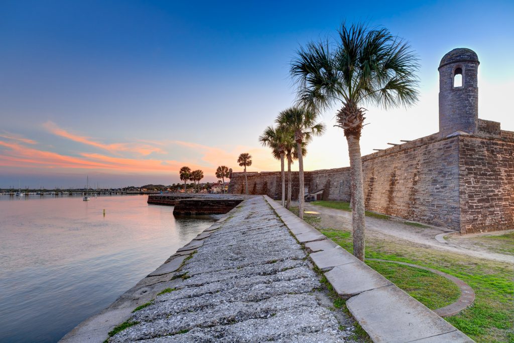 A view along the sea wall in St Augustine, FL, with the ancient Castillo de San Marcos on the right and water on the left