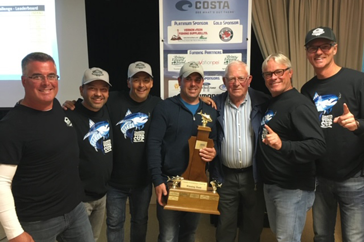 Seven people posing with a trophy after winning the PEI Tuna Cup Challenge