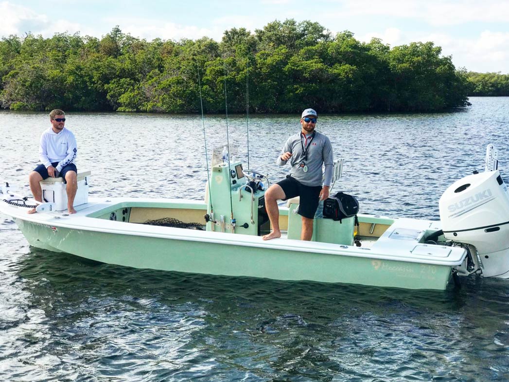 Dois homens sentam-se num barco charter no rio índio