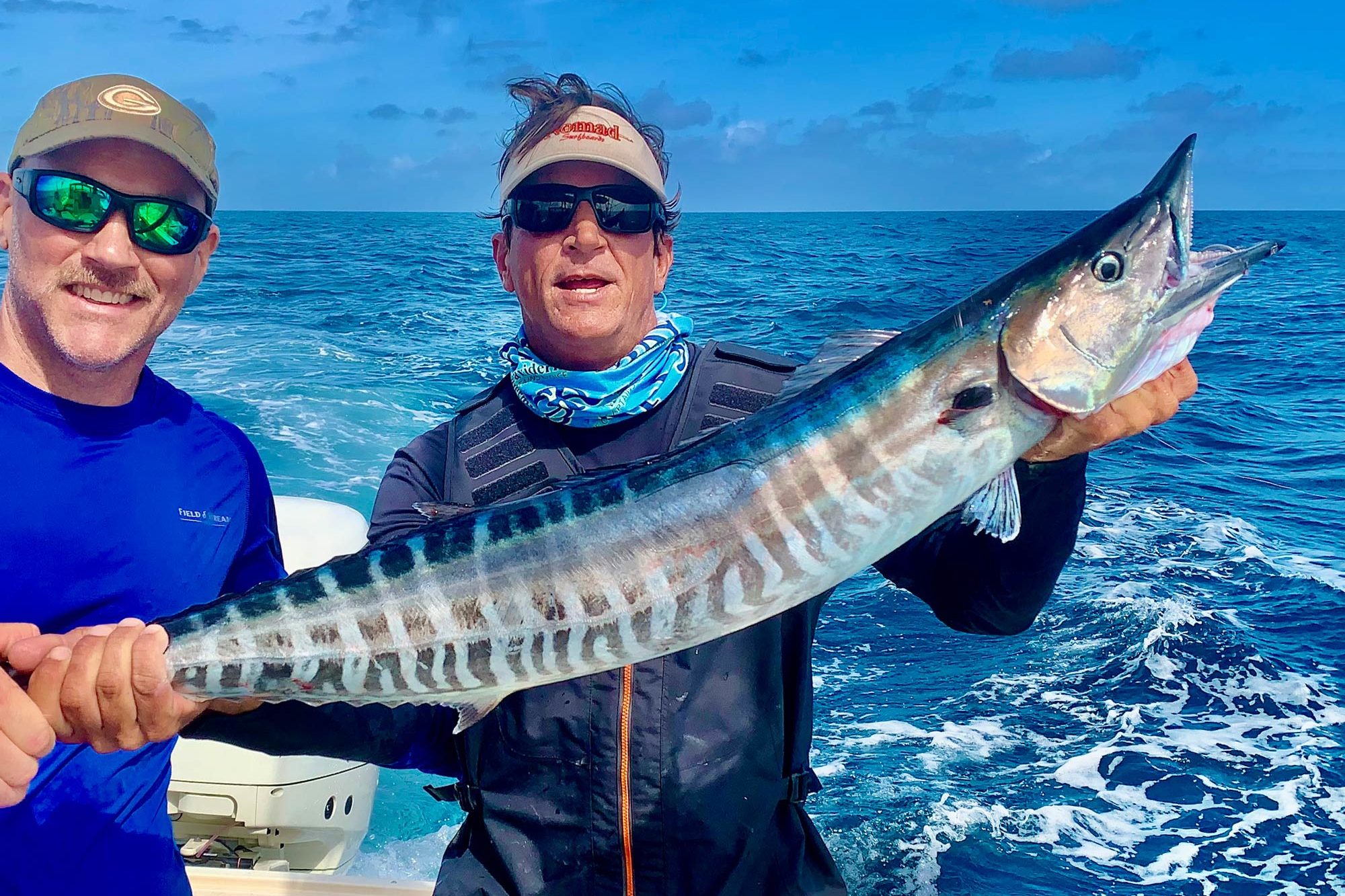 Two anglers posing with a nice Wahoo on a boat