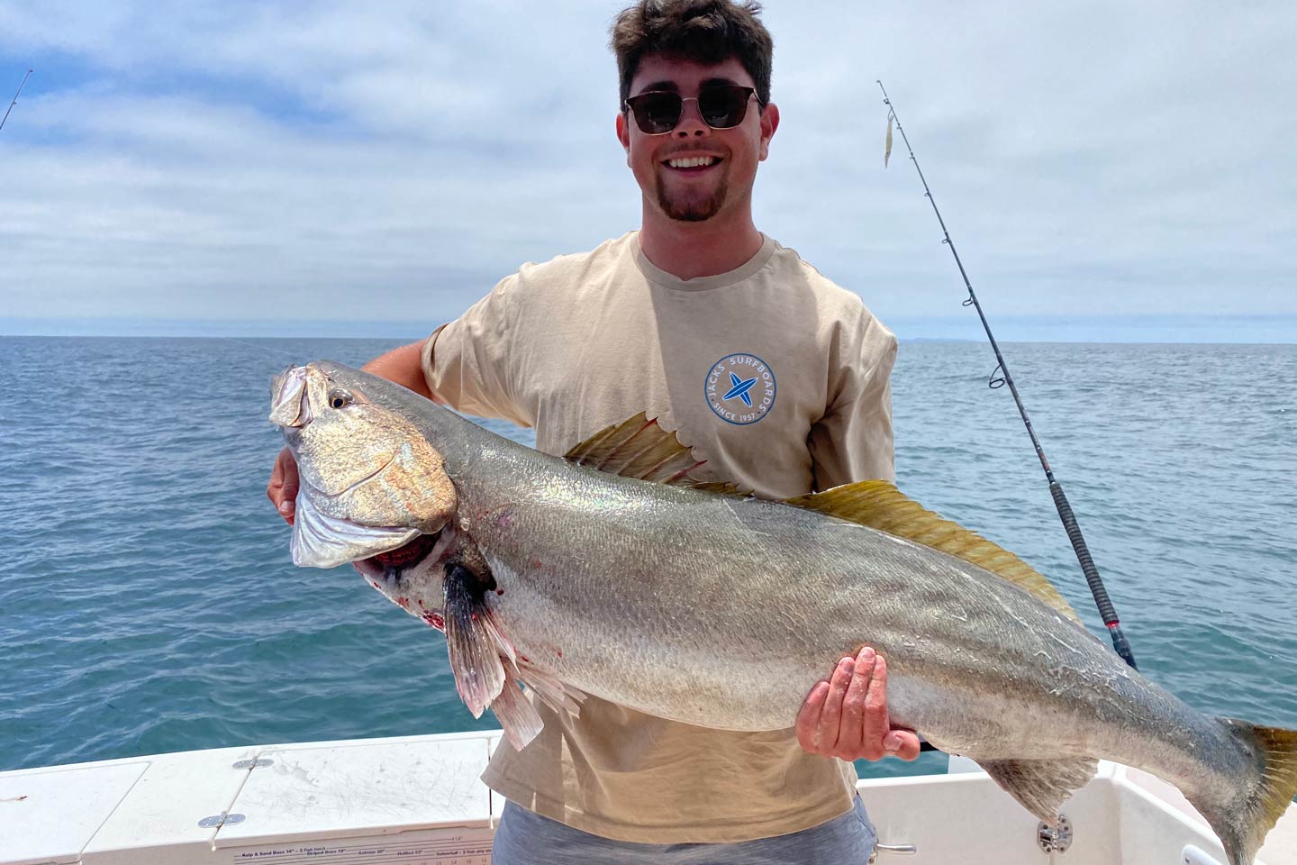 A young male angler happily showing off a White Seabass, caught in the waters off the coast of Catalina.