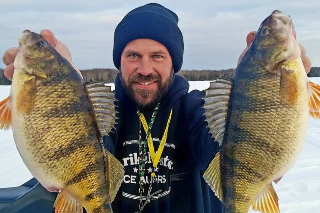 A man holds two large Yellow Perch after ice fishing on Lake Michigan