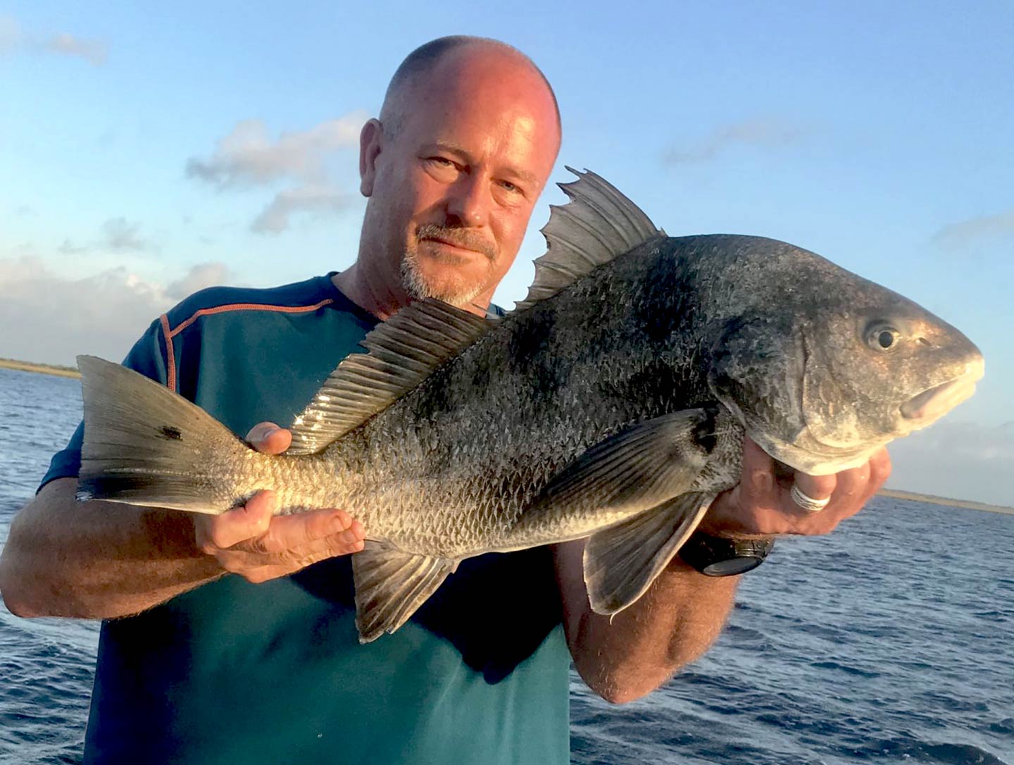 Ein Mann, der eine Black Drum hält