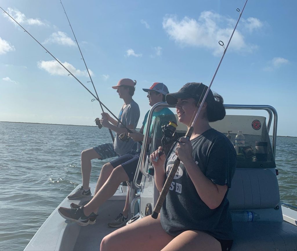 family fishing on a boat during covid-19, showing that fishing is a great guilt-free activity to enjoy during the covid pandemic