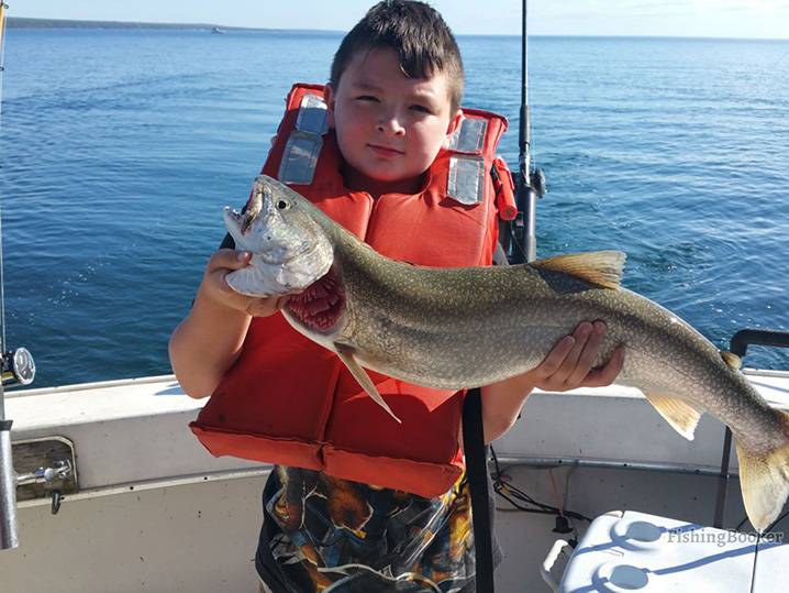 A young boy holding Walleye which he caught on a fishing trip with his family on the waters of the Lake of the Woods.