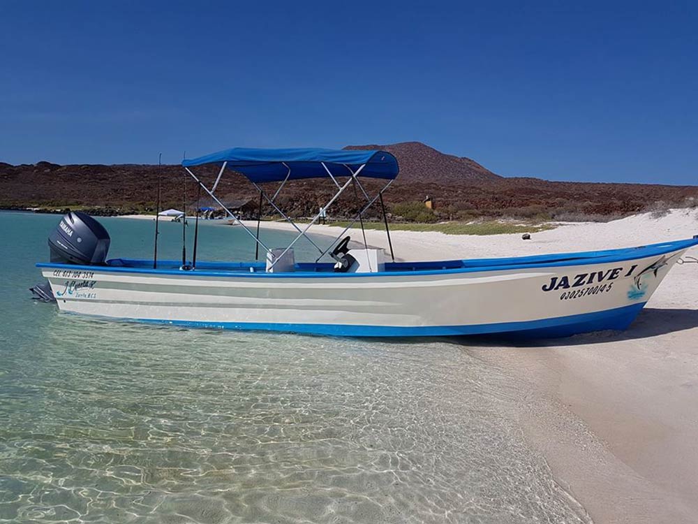 A panga boat lies in the sands in Baja California Sur on a sunny day.