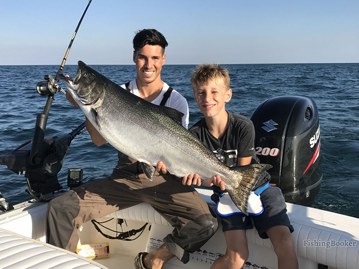 A dad and his son holding a Salmon they caught on their family fishing trip in Port Washington.