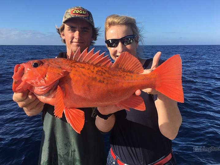 A mom and her son holding Rock Cod fish on a family trip in San Diego